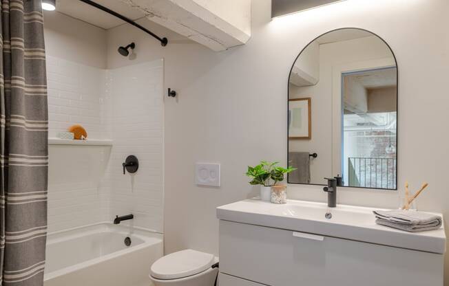 a bathroom with a white sink and toilet next to a white bathtub at The 22 Apartments, Missouri