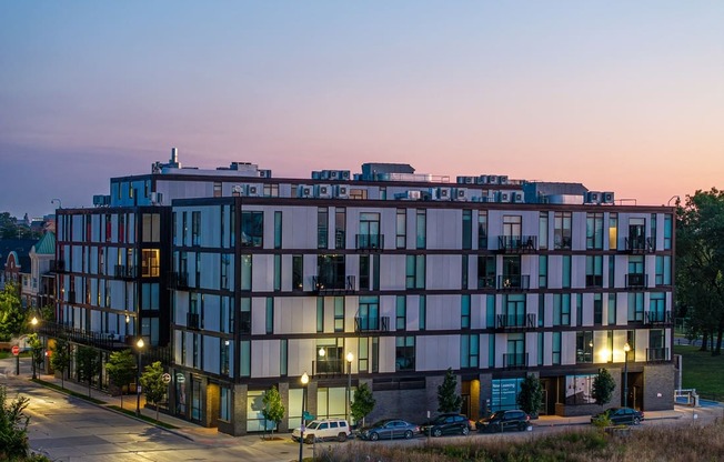 a view of a building at dusk with street lights