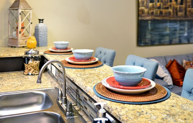 a kitchen with a sink and a counter with plates on it