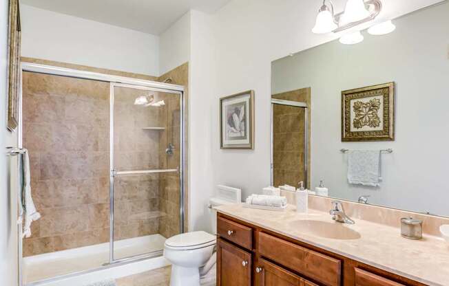 A bathroom with a toilet, sink, and shower.