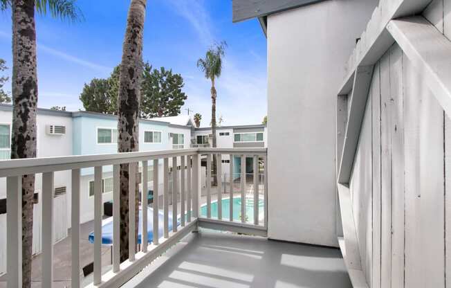 a balcony with a pool and palm trees