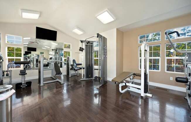 a gym with weights machines and a tv on the wall