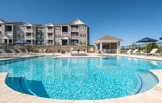 a swimming pool with an apartment building in the background  at Aventura at Hawk Ridge, Lake St Louis