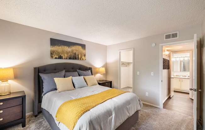 A bedroom with a large bed and a painting on the wall.