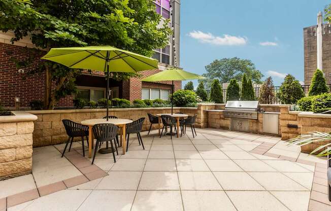 A patio with a table and chairs under a green umbrella.