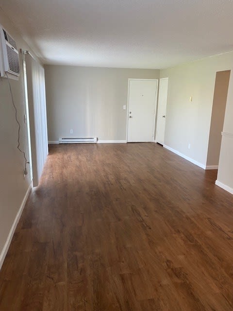 an empty living room with a hardwood floor