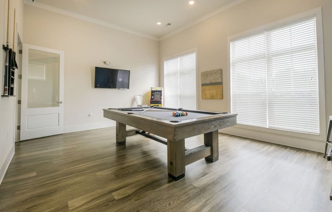 a game room with a pool table and a tv