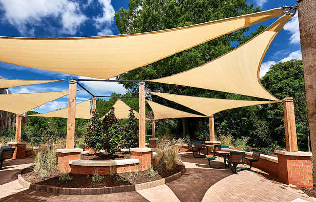 A patio with a yellow canopy and a fire pit.