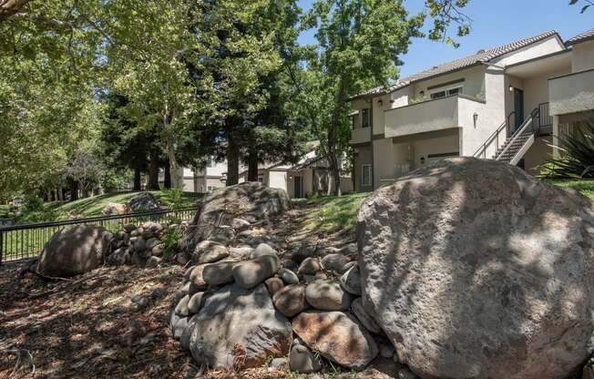 Stanford Heights apartments landscaping boulders and trees in front of a building