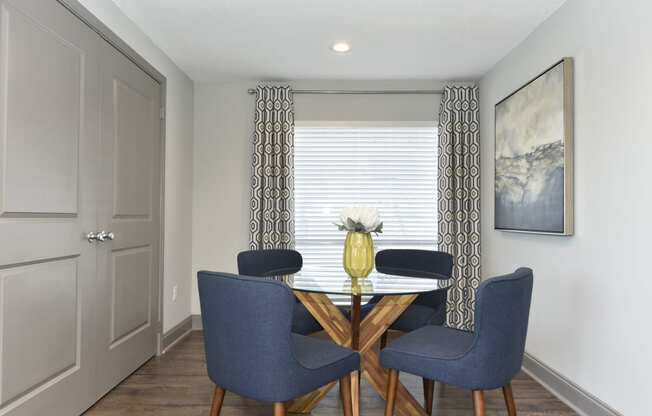 a dining room with a table and four chairs