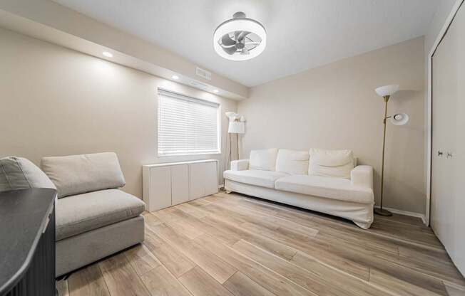 A living room with a white couch and a grey sofa.