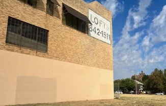 A Lofts sign is on a building with a blue sky in the background.