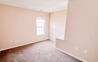 an empty room with carpet and a window