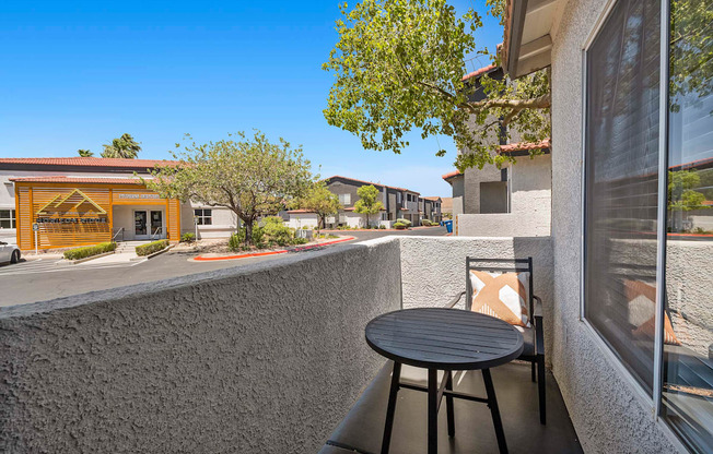 A patio with a table and chairs overlooking a street.