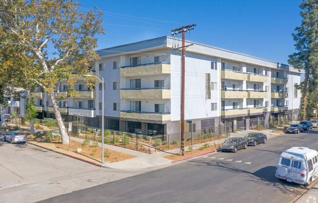 an image of an apartment building with cars parked in front of it