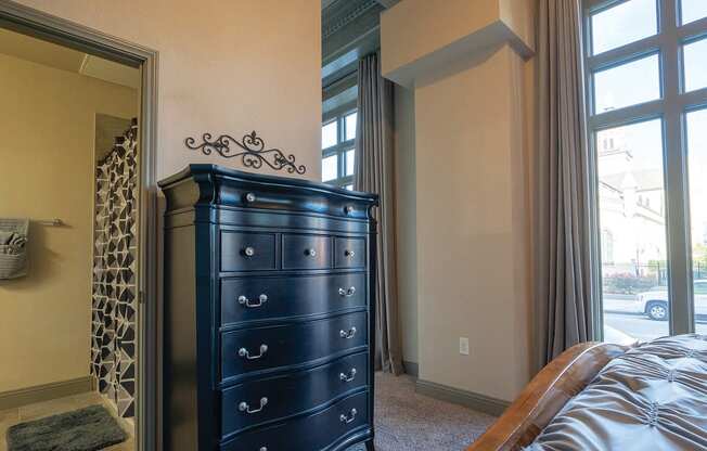 a bedroom with a dresser and a window