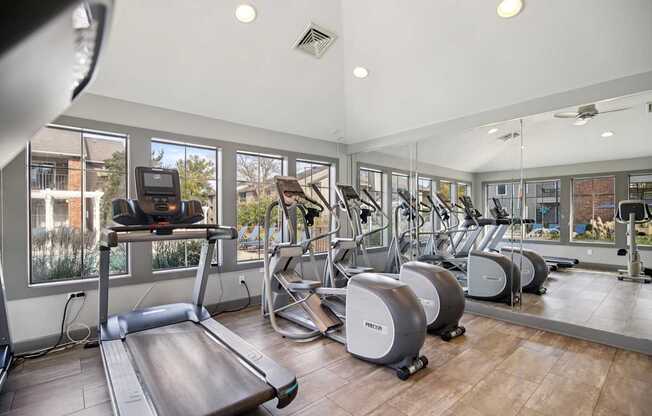 A gym with treadmills, elliptical machines and other exercise equipment.