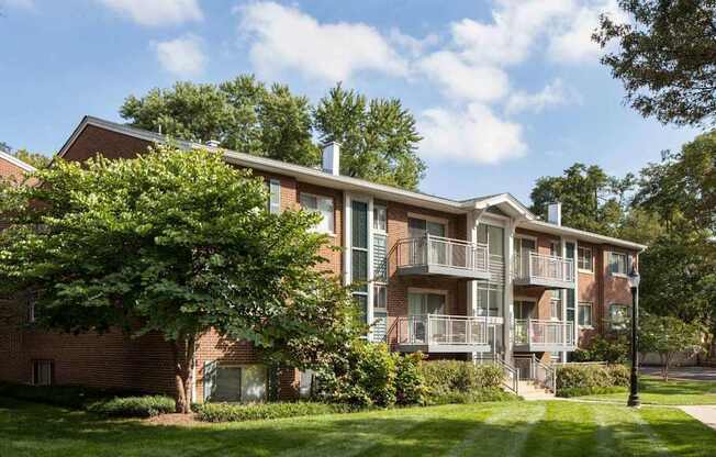 A large apartment building with a green lawn in front.