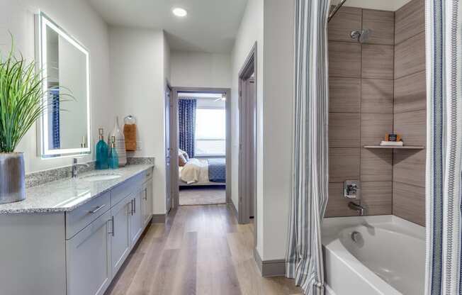 a bathroom with a tub and a shower and a sink