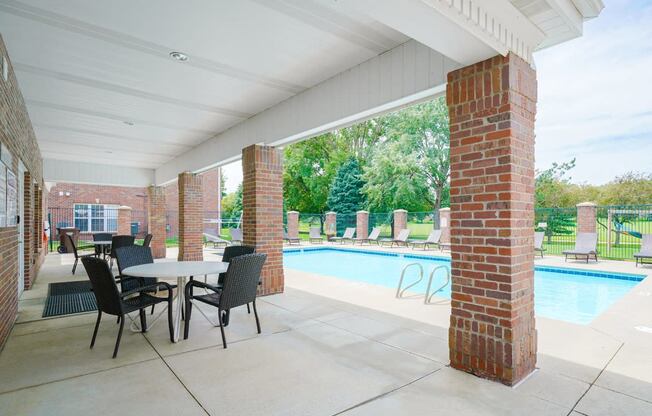 Poolside shaded patio with table and chairs