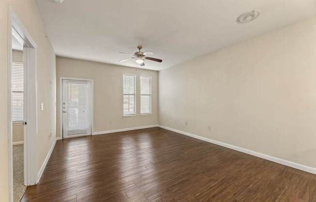A room with wooden floors and a ceiling fan.