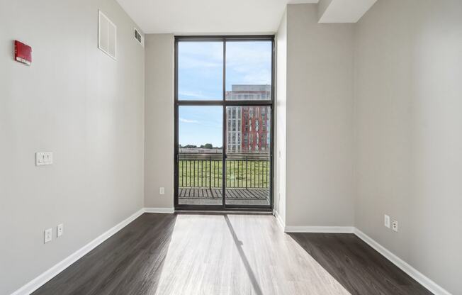 an empty living room with a door to a balcony