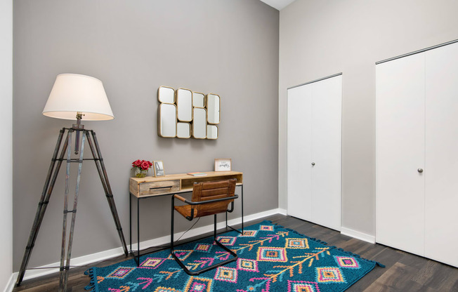 a home office with a tripod desk and a tripod lamp