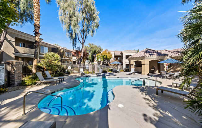A swimming pool surrounded by palm trees and apartment buildings.
