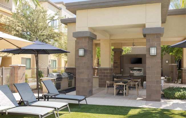 A patio with a table, chairs and an umbrella.