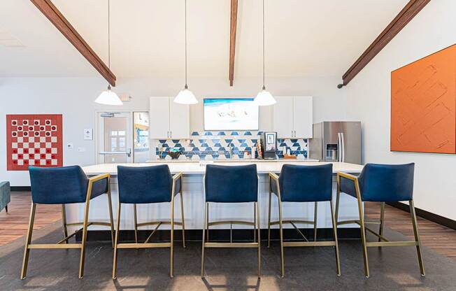 A dining room with a checkered tablecloth and blue chairs.