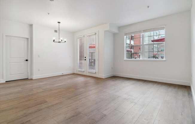 an empty living room with white walls and a window