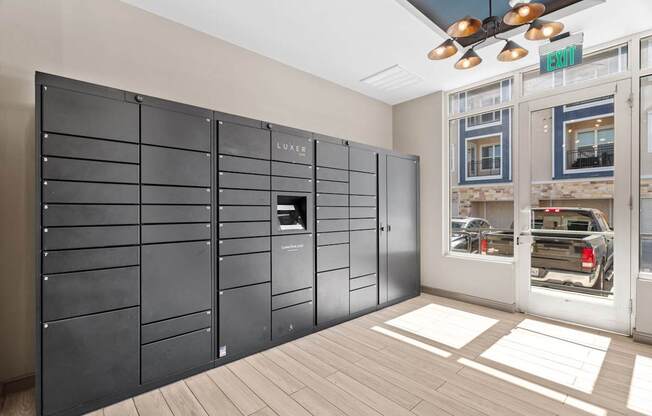 A black wall with a row of lockers and a sign that says "EXIT" above it.