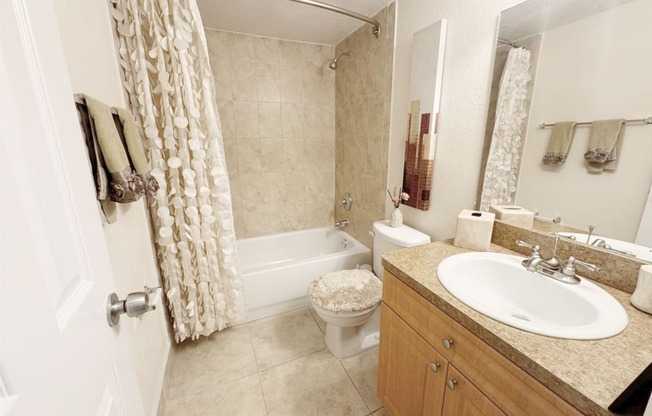 a bathroom with a sink toilet and tub and a shower curtain