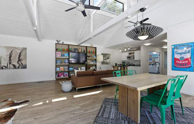 A room with a table, chairs and a ceiling fan.