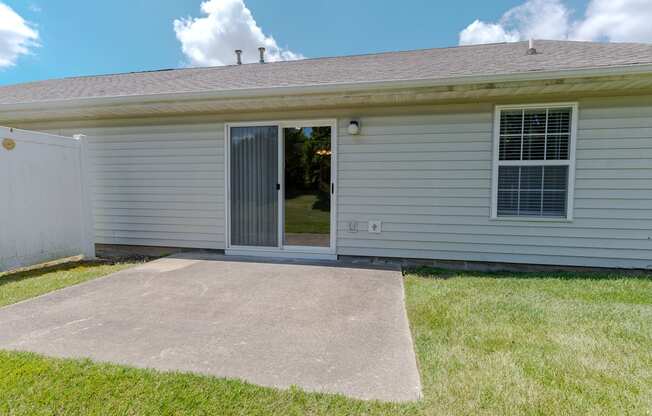 the front of a white house with a concrete driveway