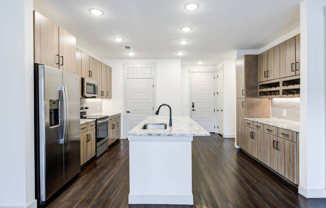a large kitchen with stainless steel appliances and marble counter tops