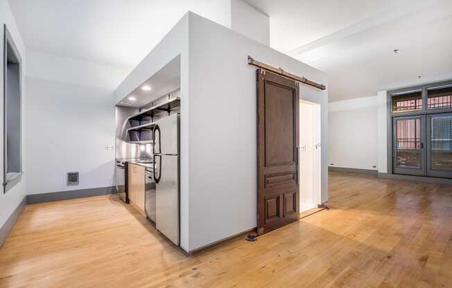 a large kitchen with a stainless steel refrigerator and a wooden door