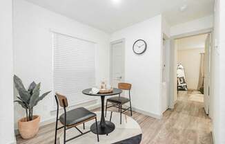 A dining room with a table and chairs.