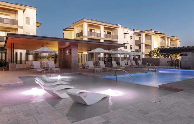 a swimming pool at a resort with chairs and umbrellas