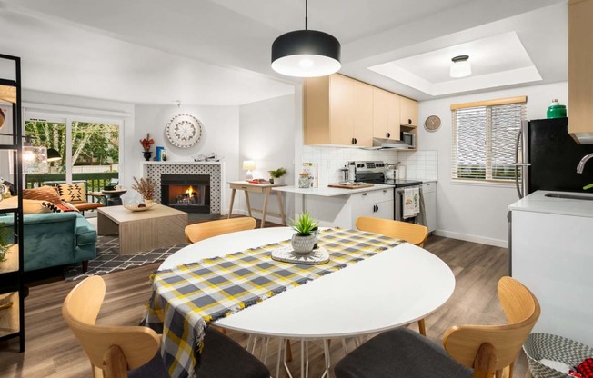 a living room and kitchen with a table and a fireplace