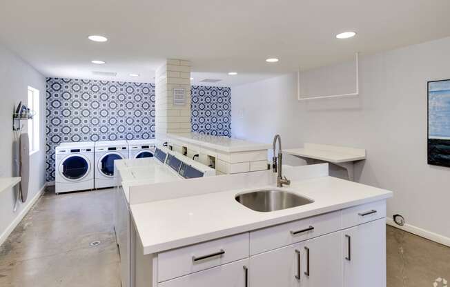 a white kitchen with a sink and a laundry room