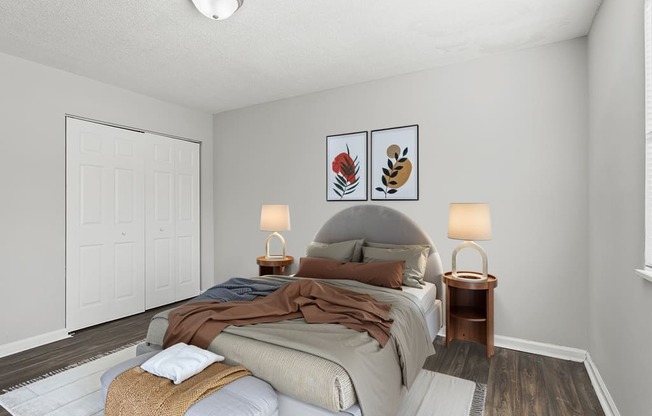 Element at 4411 Macon Apartments A bedroom with a bed, two lamps, and a painting on the wall.