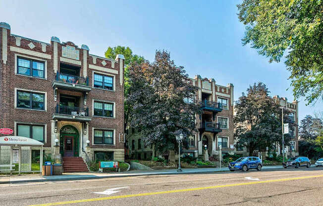 A street view of a building with a blue car parked in front.