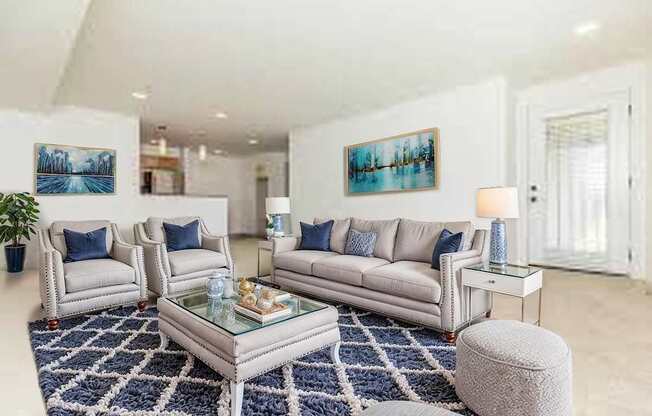 A living room with a white couch, a glass coffee table, and a blue rug.