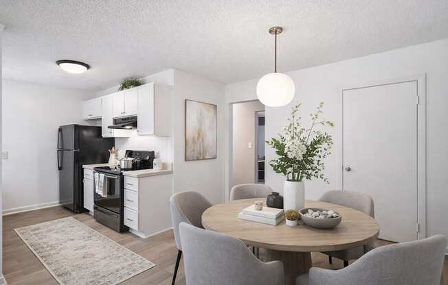 A modern kitchen with a dining table and grey chairs.