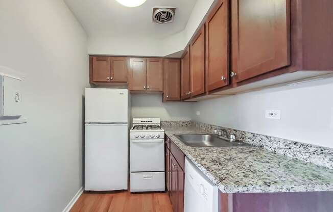 a kitchen with white appliances and granite countertops