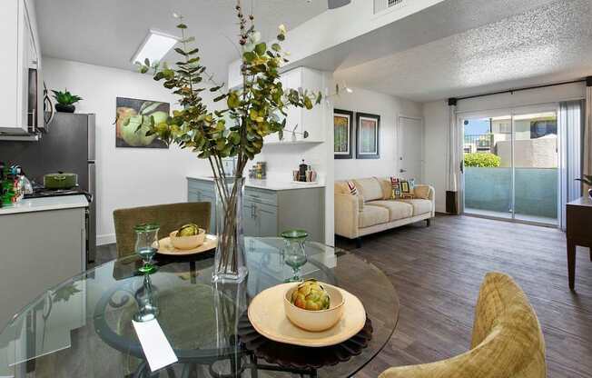 A modern dining room with a glass table and chairs.