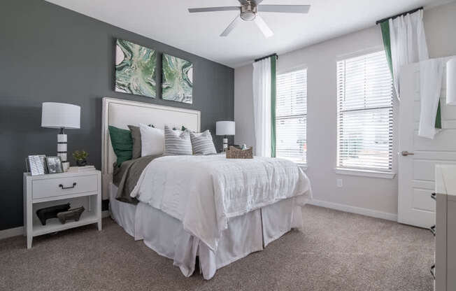 an open bedroom with a bed and a ceiling fan