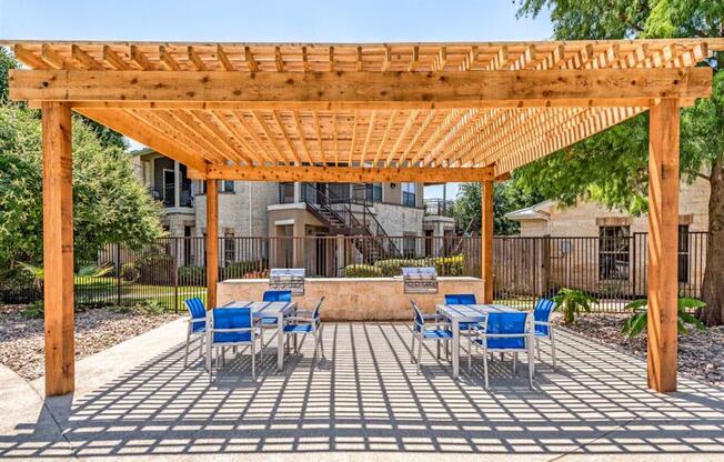 Dog-Friendly Apartments in Grand Prairie, TX - Forum at Grand Prairie - Picnic Area with Two BBQ Stations and Two Dining Areas Under a Pergola