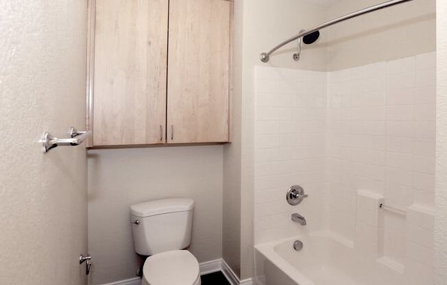 a bathroom with a toilet and a tub and a sink